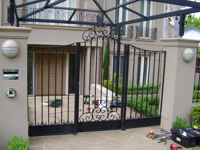 Black wrought iron fence and swing gate Black wrought iron fence and swing gate